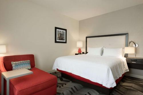 a hotel room with a bed and a red chair at Hampton Inn by Hilton Spring Hill, TN in Kedron