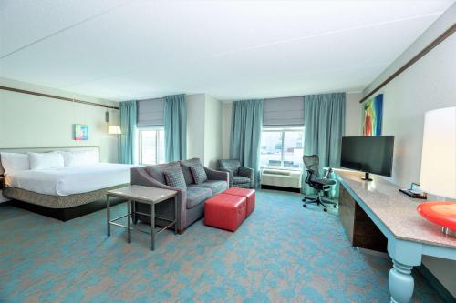 a hotel room with a bed and a living room at Hilton Garden Inn Asheville Downtown in Asheville