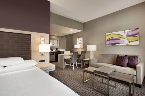 シャーロットにあるEmbassy Suites by Hilton Charlotte Uptownのベッドとリビングルームが備わるホテルルームです。