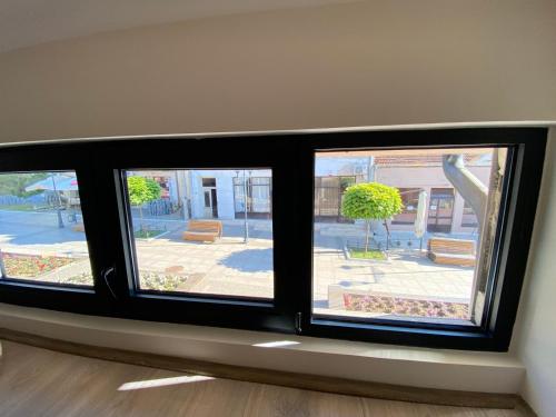 a window with three views of a courtyard at UB Prenociste in Vranjska Banja