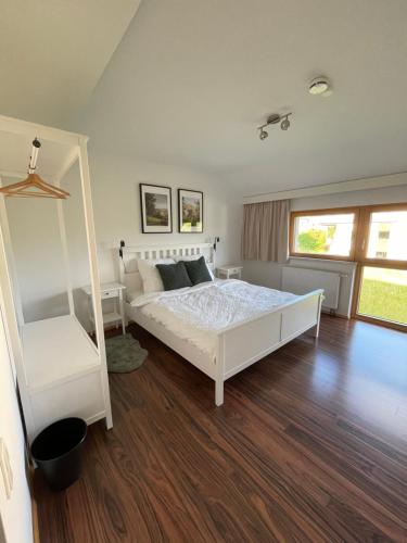 Schlafzimmer mit einem weißen Bett und Holzboden in der Unterkunft Gut Schlafen - Am Kogl in Hypolz
