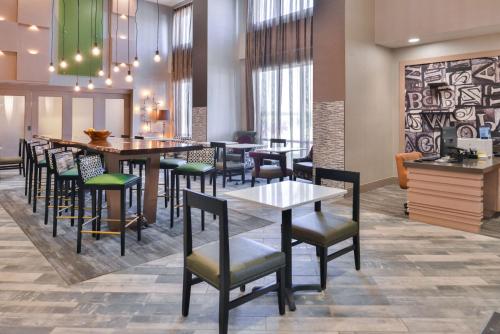 a restaurant with a bar with chairs and tables at Hampton Inn and Suites Altoona-Des Moines by Hilton in Altoona