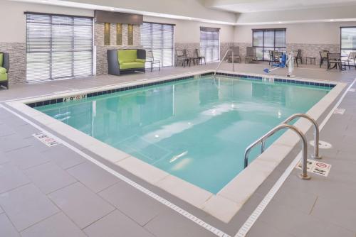 Hampton Inn and Suites Altoona-Des Moines by Hilton في ألتونا: مسبح كبير مع ماء أزرق في مبنى