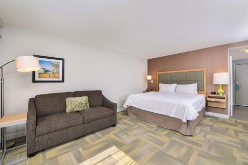 a hotel room with a bed and a couch at Hampton Inn and Suites Altoona-Des Moines by Hilton in Altoona