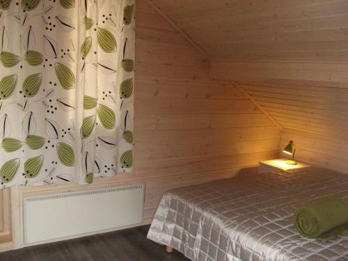 薩翁林納的住宿－Holiday Villa Kerimaa 18，木制客房内的一间卧室,配有一张床