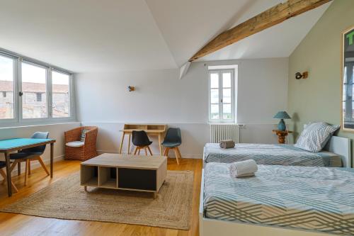 een woonkamer met een bed en een tafel bij Grand appartement de Standing #Hypercentre in Cognac