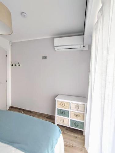a bedroom with a bed and a dresser and a window at Arrecife Beach in La Pineda