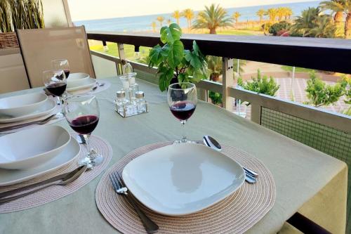 a table with two glasses of red wine on a balcony at Arrecife Beach in La Pineda