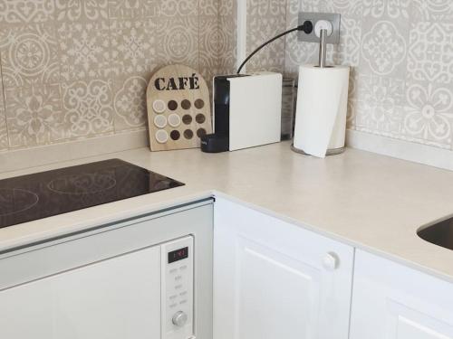 a kitchen with a white counter top with a lamp at Arrecife Beach in La Pineda