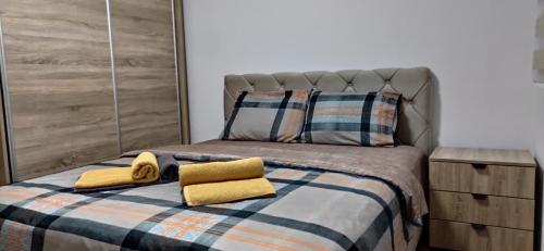 a bed with two yellow towels on top of it at Chill out apaRtMent in Foča