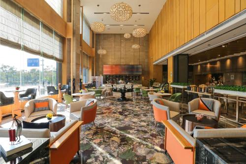 a restaurant with chairs and tables and a bar at Hilton Garden Inn Foshan in Foshan