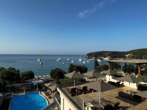 a view of a resort with a pool and boats in the water at Valtos Beach Hotel in Parga