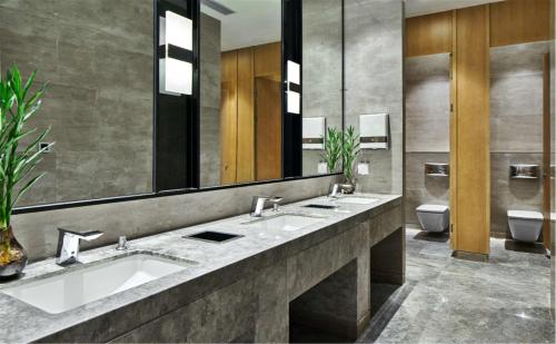 a bathroom with two sinks and a large mirror at Hilton Garden Inn Foshan in Foshan