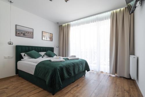 a bedroom with a bed and a large window at SOLEK Apartamenty i pokoje gościnne in Mielno