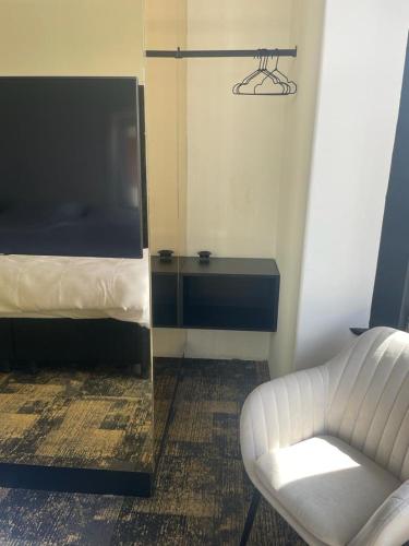 a room with a mirror and a chair and a bed at Bed & Breakfast Maison Noire Westende-bad incl parking & ontbijt in Middelkerke