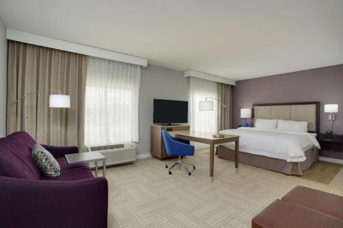 オレンジパークにあるHampton Inn and Suites Jacksonville/Orange Park, FLのベッドとデスクが備わるホテルルームです。