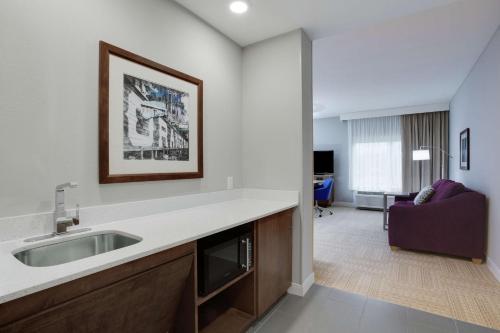 a kitchen with a sink and a living room at Hampton Inn and Suites Jacksonville/Orange Park, FL in Orange Park