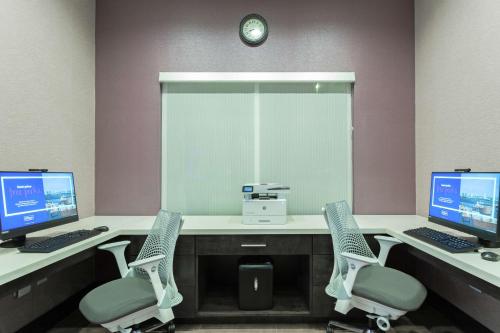 a waiting room with two computer monitors and chairs at Hampton Inn and Suites Jacksonville/Orange Park, FL in Orange Park