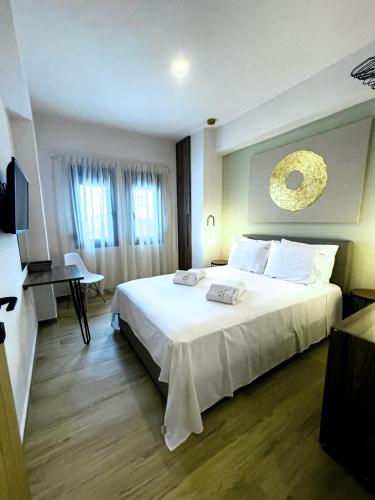 a bedroom with a large white bed and a desk at ATHONITE all seasons luxury suites in Ierissos