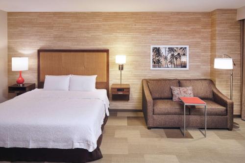 カポレイにあるHampton Inn & Suites Oahu Kapolei - FREE Breakfast & Parkingのベッドとソファ付きのホテルルーム