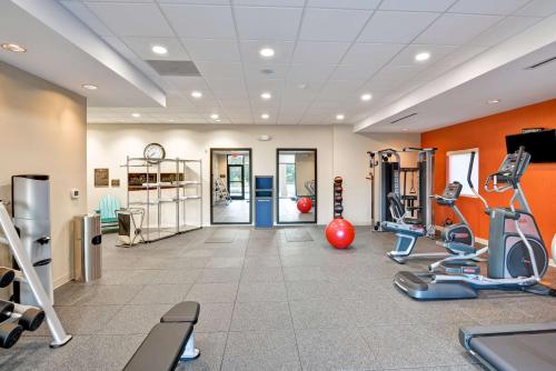 a gym with cardio equipment in a room with orange walls at Home2 Suites By Hilton Stafford Quantico in Stafford