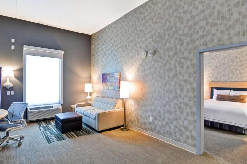 a hotel room with a bed and a chair at Home2 Suites By Hilton Stafford Quantico in Stafford