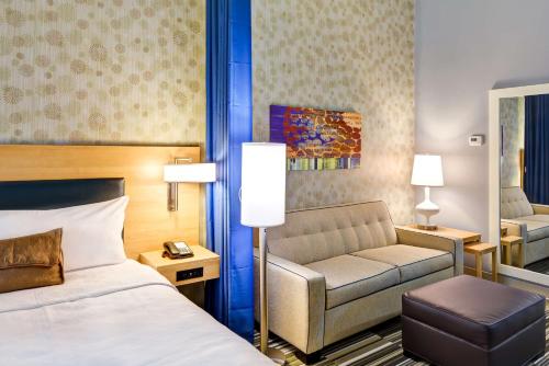 een hotelkamer met een bed en een bank bij Home2 Suites By Hilton Stafford Quantico in Stafford