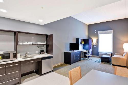 a kitchen and living room with a desk and a couch at Home2 Suites By Hilton Stafford Quantico in Stafford