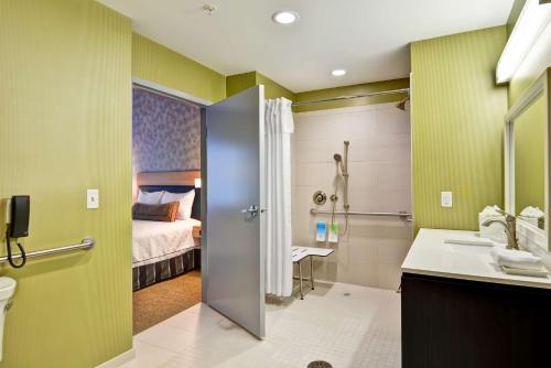 uma casa de banho com uma cama, um lavatório e um WC. em Home2 Suites By Hilton Stafford Quantico em Stafford