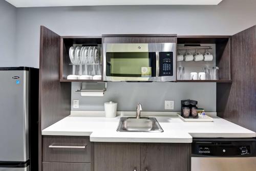 a kitchen with a sink and a microwave at Home2 Suites By Hilton Stafford Quantico in Stafford