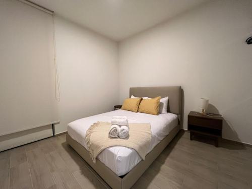 een slaapkamer met een bed met twee handdoeken erop bij Departamento Ajijic Jalisco. in Jocotepec