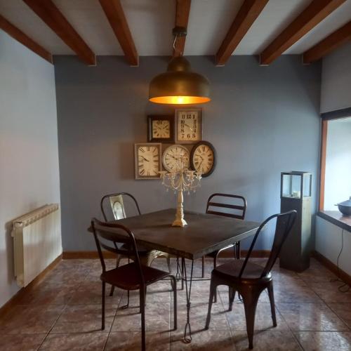 comedor con mesa, sillas y relojes en Maison de charme, raffinée dans village historique, en Vervant