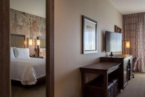 a hotel room with a bed and a mirror at Hampton Inn & Suites Murrieta in Murrieta