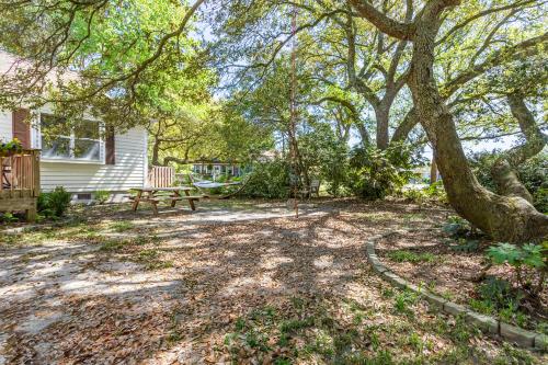 a yard with a bench and a tree at Sea Cave, OBX gem, private studio, couple's nest! in Kill Devil Hills