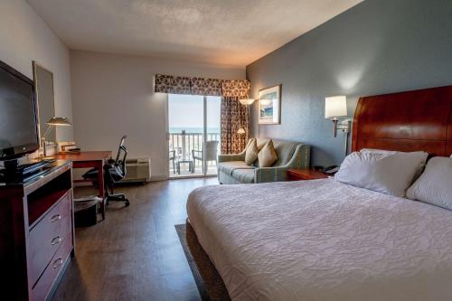 Habitación de hotel con cama, escritorio y TV. en Hilton Garden Inn Outer Banks/Kitty Hawk, en Kitty Hawk
