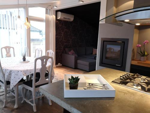 a kitchen and living room with a table and a couch at Cosy apartment on a quiet street in Kristiansand