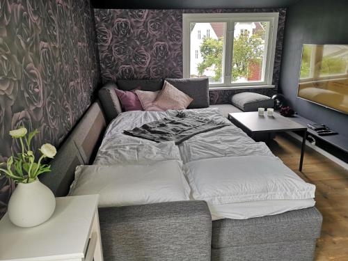 Dormitorio pequeño con cama y mesa en Cosy apartment on a quiet street en Kristiansand