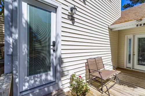 a chair sitting on a porch next to a door at Sea Cave, OBX gem, private studio, couple's nest! in Kill Devil Hills