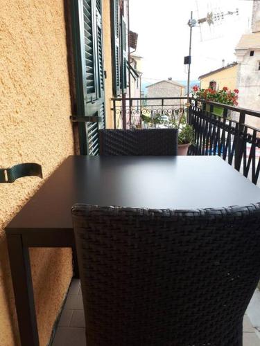 uma mesa preta e cadeiras numa varanda em Casa Assunta em Corvara