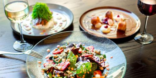 a table with plates of food and glasses of wine at The Desmond Hotel Malvern, a DoubleTree by Hilton in Malvern