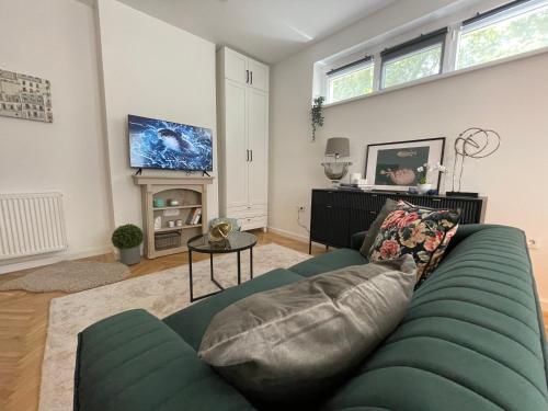 ein Wohnzimmer mit einem blauen Sofa und einem TV in der Unterkunft Number4 in Szeged