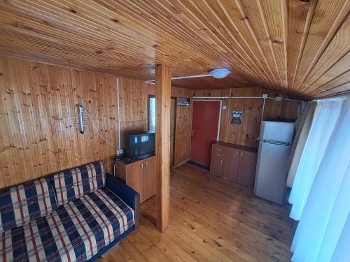 una sala de estar con sofá y TV en una casa en Olive cabin - Kuća maslina i mira u Đenovićima!, en Herceg-Novi