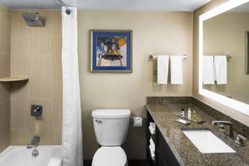 a bathroom with a toilet and a sink and a mirror at The Desmond Hotel Malvern, a DoubleTree by Hilton in Malvern