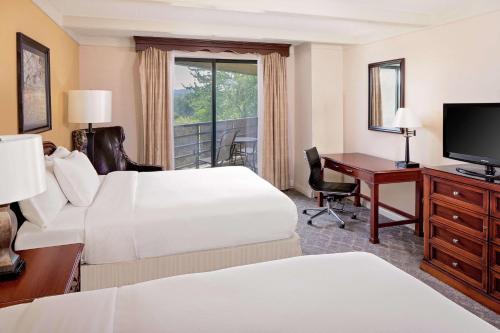 a hotel room with a bed and a desk and a computer at The Desmond Hotel Malvern, a DoubleTree by Hilton in Malvern