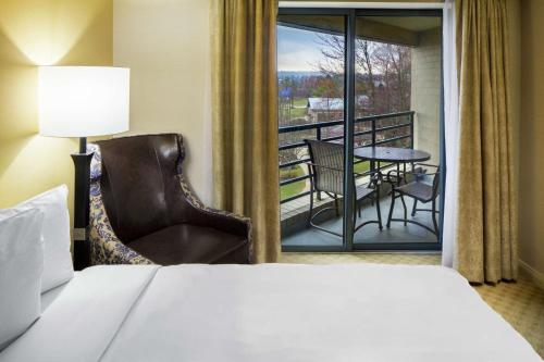 a hotel room with a bed and a balcony at The Desmond Hotel Malvern, a DoubleTree by Hilton in Malvern