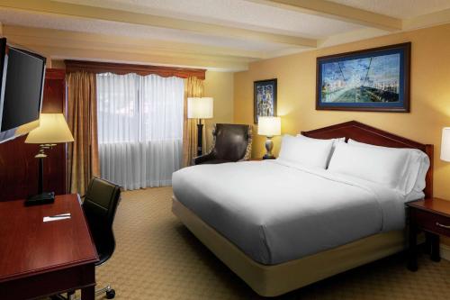 a hotel room with a large bed and a desk at The Desmond Hotel Malvern, a DoubleTree by Hilton in Malvern