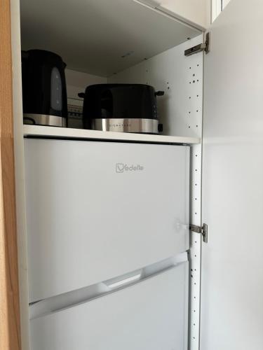 een witte koelkast met twee pannen erop bij STUDIO VUE PORT PISCINE PARKING in Cap d'Agde