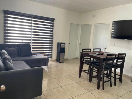 a living room with a table and a couch at Departamento para familias in Mazatlán