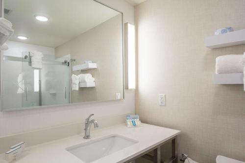 a bathroom with a sink and a mirror at Hilton Garden Inn Salina in Salina