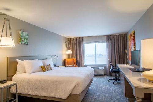una camera d'albergo con letto, scrivania e TV di Hilton Garden Inn Salina a Salina